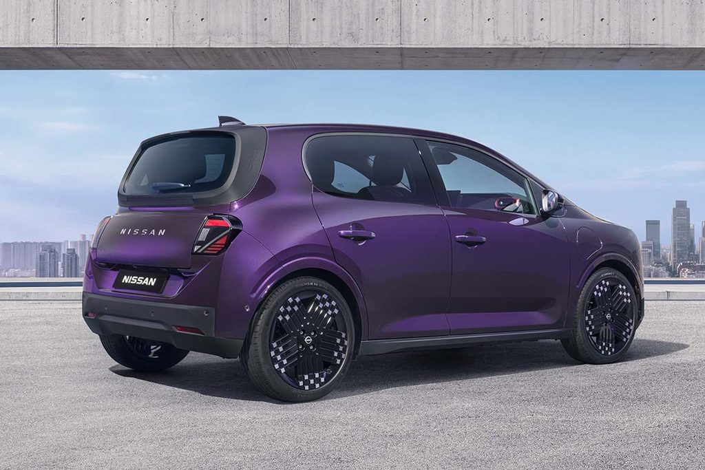 Three-quarter rear view of a purple Nissan PIXO electric city car parked beneath a modern concrete structure, with a city skyline in the background.
